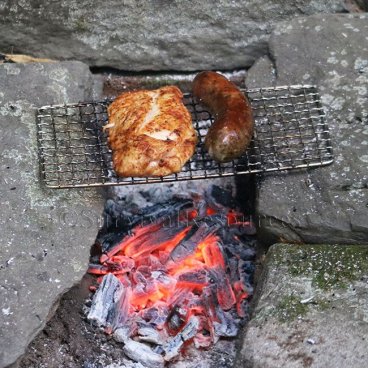 Mini Bushcraft Pack Grill over coals on a keyhole fire pit